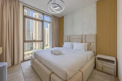 a bedroom with a large bed with a large window at Vacationer l 1 Bedroom in Creek Harbour l Skyline Views in Dubai