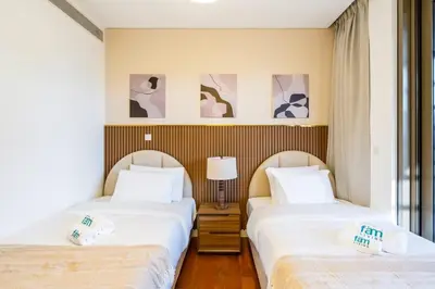 two beds sitting next to each other in a room at Elegant 3BR with Maids Room City Walk Dubai in Dubai