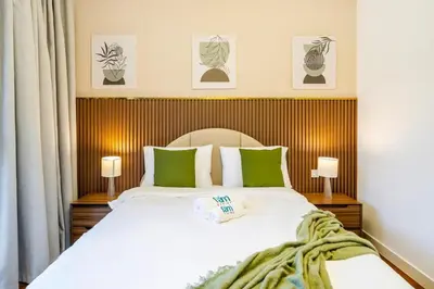 a bedroom with a large white bed with green pillows at Elegant 3BR with Maids Room City Walk Dubai in Dubai