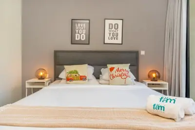 a bedroom with a large white bed with two tables at Stylish 2BR with Maids Room City Walk in Dubai