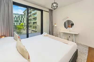 a bedroom with a white bed and a large window at Stylish 2BR with Maids Room City Walk in Dubai