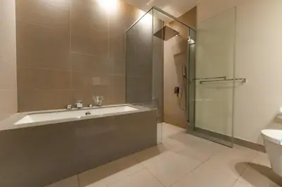 a bathroom with a tub and a glass shower at Spacious 2BR with Maids Room City Walk in Dubai