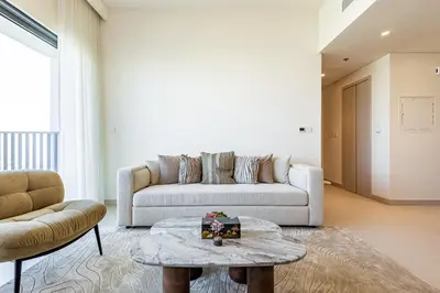 a living room with a couch and a table at Superhost - 1BR Apartment, Balcony, Pool & Gym , Dubai Hills in Dubai