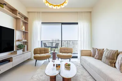 a living room with a couch and a tv at Superhost - 1BR Apartment, Balcony, Pool & Gym , Dubai Hills in Dubai