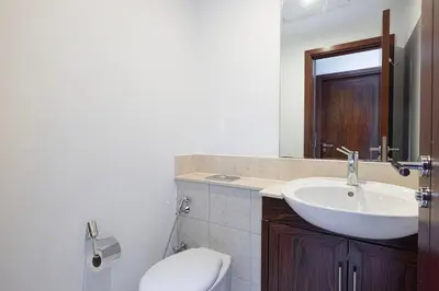 a bathroom with a white sink and a toilet at Large 4 Bed Apt with Burj View and 8 Min Walk to Mall by Vista Stays DXB in Dubai