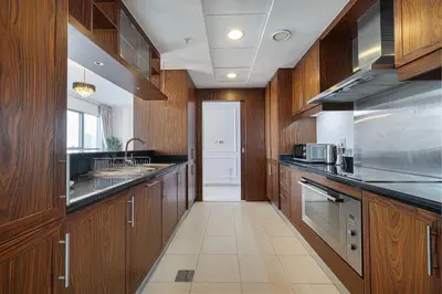 a large kitchen with wooden cabinets and a sink at Large 4 Bed Apt with Burj View and 8 Min Walk to Mall by Vista Stays DXB in Dubai