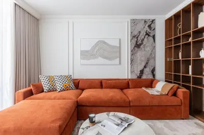 a living room with a orange couch and a table at Luxury & Modern Unit in Emaar Beachfront in Dubai