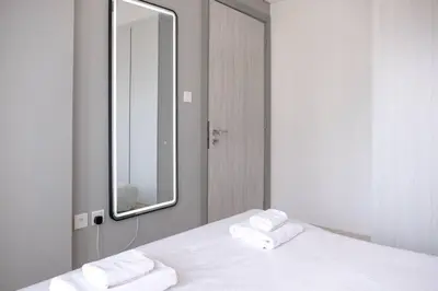 a bedroom with a white bed with a mirror at Zada Tower, Business Bay - Onelink in Dubai