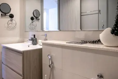 a white bathroom with a sink and a mirror at Zada Tower, Business Bay - Onelink in Dubai