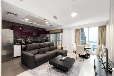 a living room and kitchen with a couch and a table at Cayan Tower, Dubai Marina - Onelink in Dubai