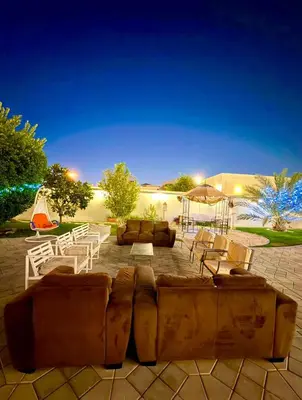 a patio with couches and tables and an umbrella at Risephoenix Japanese Luxury Capsule Villa - Dubai in Dubai