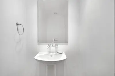 a white bathroom with a sink and a mirror at Silkhaus in Al Tajer in Souk al Bahar Direct Access in Dubai