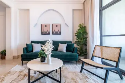 a living room with a green couch and chairs at Silkhaus in Al Tajer in Souk al Bahar Direct Access in Dubai