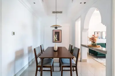a dining room with a wooden table and chairs at Silkhaus in Al Tajer in Souk al Bahar Direct Access in Dubai