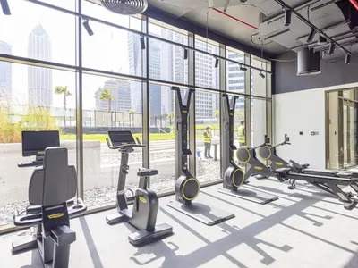 a gym with treadmills and cardio equipment in a building at Peninsula One Suites by Prestige Nest in Dubai