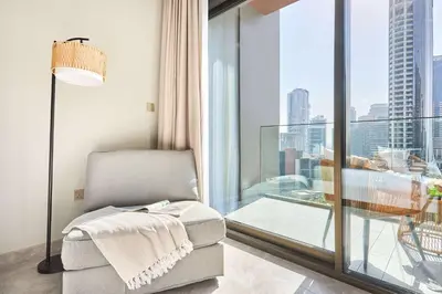 a living room with a chair and a large window at Frank Porter - Peninsula One in Dubai