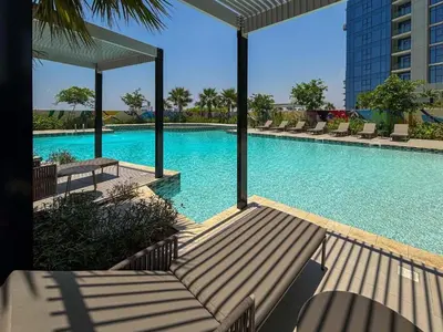 a large swimming pool with lounge chairs in a building at The Iconic Stay 2BR in Dubai