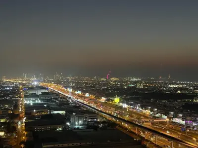a view of a city at night with lights at The Iconic Stay 2BR in Dubai