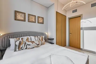 a bedroom with a bed and a wooden door at The Iconic Stay 2BR in Dubai