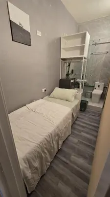 a large bed in a room with a bathroom at Partition with attached washroom in Dubai