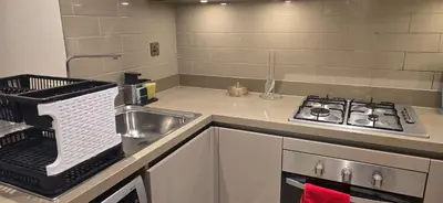 a kitchen with a sink and a stove in it at Family Friendly Studio in Dubai City Views Pool Free Parking in Dubai