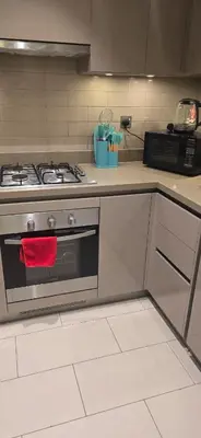 a kitchen with a stove with a red towel on it at Family Friendly Studio in Dubai City Views Pool Free Parking in Dubai