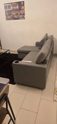 a couch with pillows sitting on the floor in a room at Family Friendly Studio in Dubai City Views Pool Free Parking in Dubai