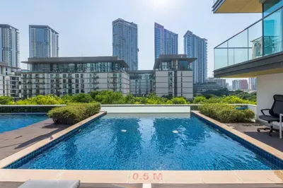a swimming pool in the middle of a building with tall buildings at Family Friendly Studio in Dubai City Views Pool Free Parking in Dubai