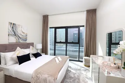 a bedroom with a white bed and a large window at Velvet Rose with Burj and canal view 2Bedrooms in Solbay in Dubai