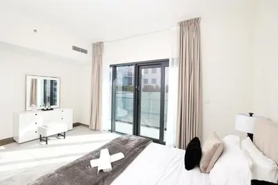 a white bedroom with a bed and a large window at Velvet Rose with Burj and canal view 2Bedrooms in Solbay in Dubai