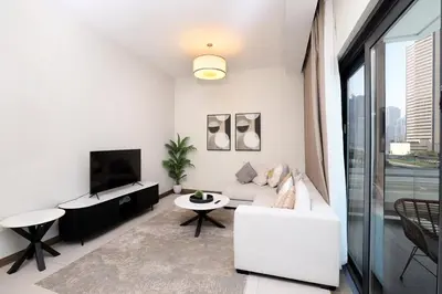 a living room with a white couch and a tv at Velvet Rose with Burj and canal view 2Bedrooms in Solbay in Dubai