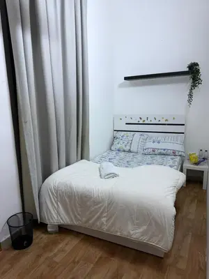 a small bed in a room with a curtain at Peaceful Budget Stay Dubai In Tecom Near Metro in Dubai