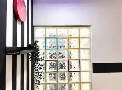 a room with a glass block wall with a clock at Peaceful Budget Stay Dubai In Tecom Near Metro in Dubai