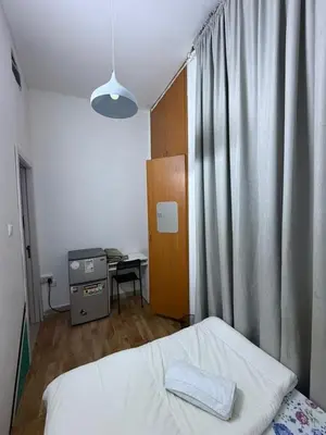 a bedroom with a bed and a desk and a window at Peaceful Budget Stay Dubai In Tecom Near Metro in Dubai