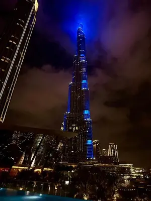 a tall building with blue lights on it at night at Full Burj Khalifa & Fountain View 60th Floor Sky Luxury 2BHK 4 mins Walk to Dubai Mall Downtown in Dubai