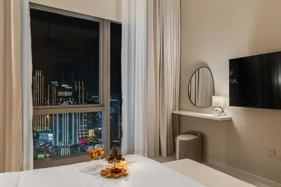 a hotel room with a window with a view of a city at Full Burj Khalifa & Fountain View 60th Floor Sky Luxury 2BHK 4 mins Walk to Dubai Mall Downtown in Dubai