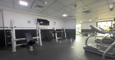 a gym with several machines and a flat screen tv at Refined Urban Studio Walk to Circle Mall in Dubai