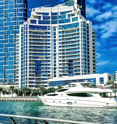 a yacht in the water in front of a large building at Barsana - Aurelia by JBR Beach - 2 Bed - Marina Views! in Dubai