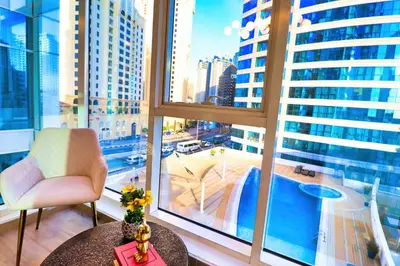 a room with a large window with a table and a chair at Barsana - Aurelia by JBR Beach - 2 Bed - Marina Views! in Dubai
