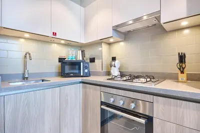 a kitchen with a sink and a stove top oven at STAY BY LATINEM Luxury 1BR Holiday Home W-407 near Burj-Khalifa in Dubai
