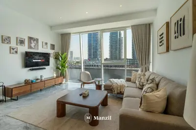 a living room with a couch and a table at Modern 1BR with Stunning Lake View in Business Bay in Dubai