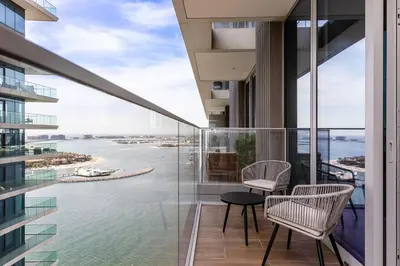 a balcony with chairs and a view of the water at Beachfront 1BR Retreat Beach Isle Tower 01 in Dubai