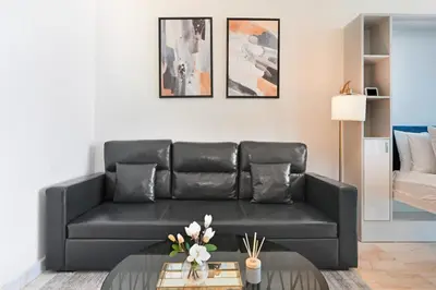 a living room with a black leather couch at Bloomfields STU in Business Bay, Bayz by Danube in Dubai