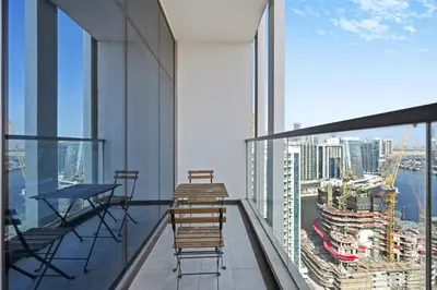 a balcony with chairs and tables on top of a building at Bloomfields STU in Business Bay, Bayz by Danube in Dubai