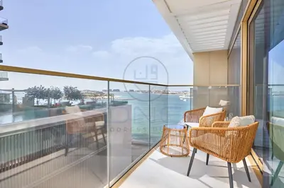 a balcony with wicker chairs and a view of the ocean at Elegant beachfront living at Emaar Beachfront DXB! in Dubai