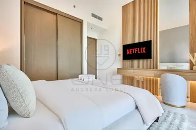 a bedroom with a large white bed and two chairs at Elegant beachfront living at Emaar Beachfront DXB! in Dubai