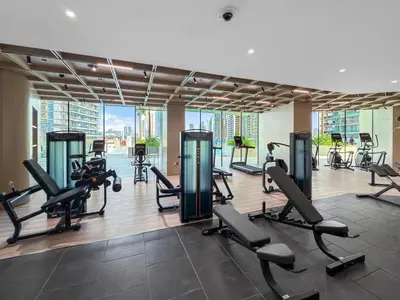 a gym with treadmills and exercise equipment in a building at Chic 1BR Retreat with Private Pool and Balcony in JVC in Dubai