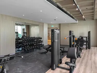 a gym with a lot of treadmills and machines at Chic 1BR Retreat with Private Pool and Balcony in JVC in Dubai