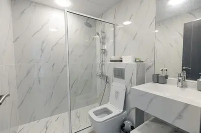 a bathroom with a shower and a toilet and a sink at Dubai Marina - 1BHK Apartment near Dubai Metro in Dubai