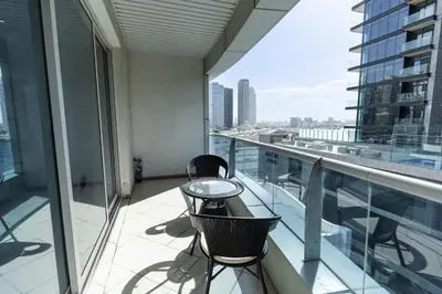 a balcony with a table and chairs on a building at Dubai Marina - 1BHK Apartment near Dubai Metro in Dubai